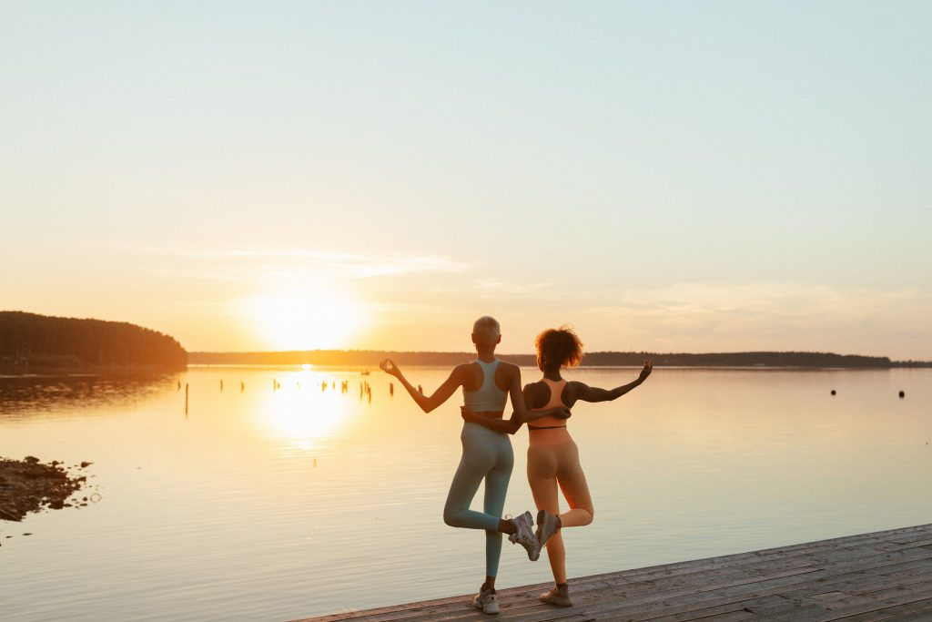 image of two girls hagging with a sunset